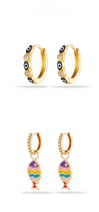 Detail view of gold hoop earrings with evil eye motifs and colorful fish pendants