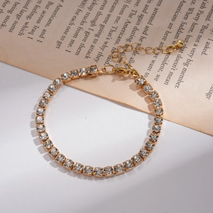 Makroaufnahme von Gold-Tennisarmband mit quadratischen Kristallen und verstellbarem Verschluss