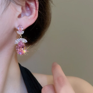 Vue détaillée des boucles d'oreilles goutte en zircon rose portées par un mannequin