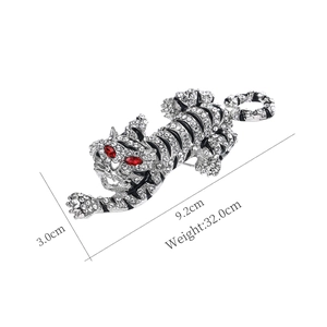Detailed size view of silver tiger brooch with rhinestones measuring 9.2cm by 3.0cm