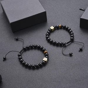 Detail of black onyx and tiger eye stone bead bracelets with gold zircon letter A charm