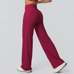 Detail of high-waisted yoga pants showing the wine red fabric and flared split leg hem