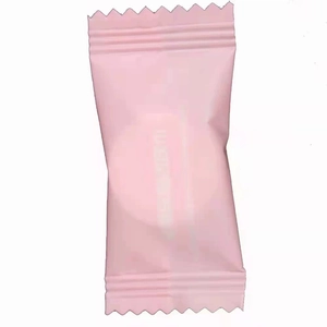 Pink disposable compressed towel in portable candy-style pouch for travel and skincare