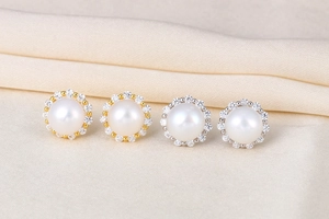 Macro detail of gold and silver S925 sterling silver pearl earrings with zircon halo