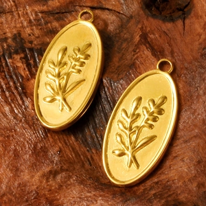 Vintage 304 stainless steel oval pendants with embossed olive branch on dark wood