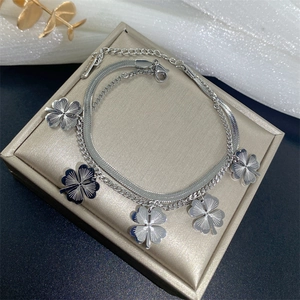Detailed macro view of silver double-layer bracelet with five engraved clover charms
