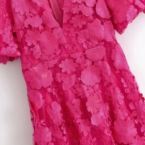 Détail de robe rose fuchsia à col en V avec broderie florale 3D et tissu en dentelle mesh