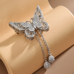 Detailed view of silver butterfly brooch with hollow wings, zircons and hanging tassels