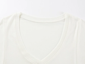 Detail shot of the V-neckline featuring premium double stitching on white wool knit top