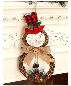 Detail of a lit snowman wreath with LED lights, plaid hat, and pine cones on fireplace
