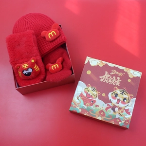 Detailed view of red knitted winter set with tiger motif in a festive gift box