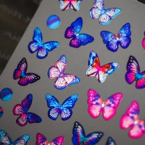 Metallic butterfly nail art stickers with vibrant electric blue and purple gradient patterns
