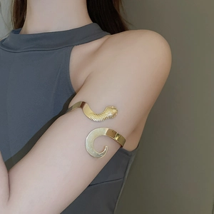 Bracelet de bras serpent en or poli montrant la texture détaillée des écailles sur peau