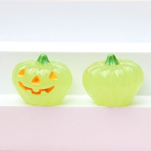 Detail of two translucent green glowing pumpkin figurines for Halloween DIY decor