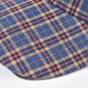 Dettaglio macro del cappello a scacchi blu e arancione con trama fitta e cuciture rinforzate