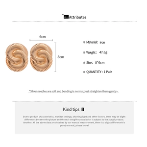 Detail of large gold spiral texture earrings with 8x6cm size and 47.6g weight specs