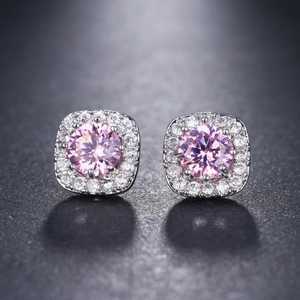 Macro detail of square pink zircon stud earrings with sparkling round center stone
