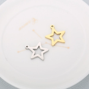 Minimalist gold and silver star pendants for DIY jewelry making on white ceramic plate