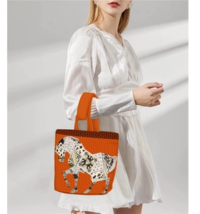 Detail of artistic horse pattern on an orange fabric handbag for vintage summer styles