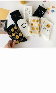 Detailed view of smiley face crew socks made of 70% cotton with material specifications