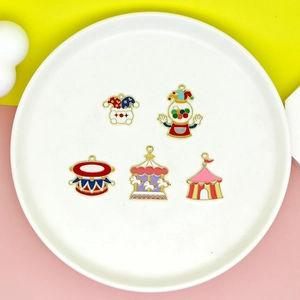 Close-up of colorful circus enamel charms including clown and carousel on a white plate