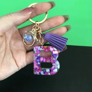 Resin letter B keychain with purple stones, suede tassel, and gold hardware