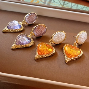 Vintage heart earrings in purple and orange with textured gold settings in a jewelry box