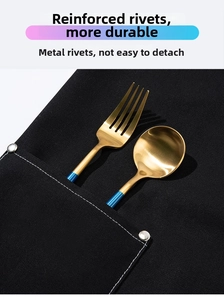 Detail of reinforced black canvas apron pocket with silver rivets and golden cutlery