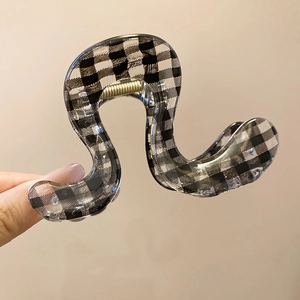 Close-up of wavy acrylic shark hair claw with stylish black and white checkered pattern