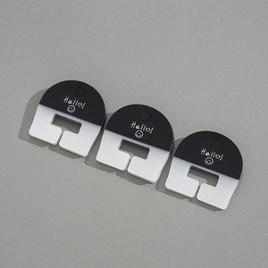 Close-up of three half-round acrylic hair clips with Hello patterns on grey background
