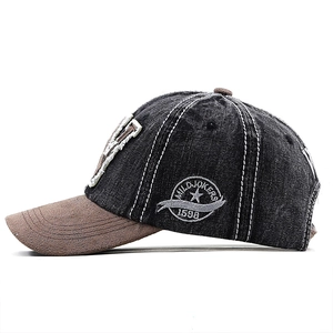 Detail of vintage denim baseball cap featuring side circular embroidery and two-tone texture