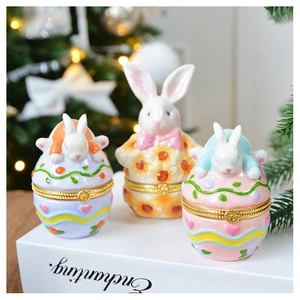 Detailed view of ceramic rabbit jewelry boxes with floral patterns and gold hinges