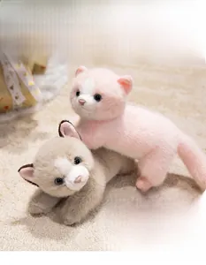 Detail of pink and grey plush Persian cats with blue glass eyes on a soft rug