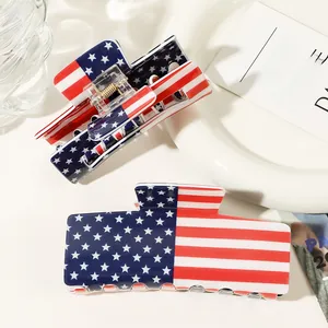Macro view of high-gloss rectangle hair claws with American flag stars and stripes pattern