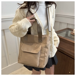 Detail of khaki nylon tote bag with front flap pocket and adjustable shoulder strap