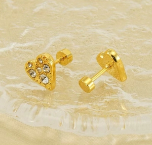Macro shot of gold-plated heart stud earrings with sparkling crystals and screw back