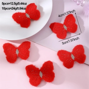 Close-up of red felt butterfly hair clips with white stitching on pink background