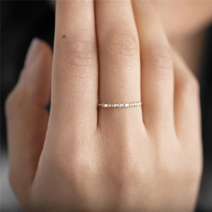 Close-up of luxury gold diamond ring on finger with sparkling stones for engagement