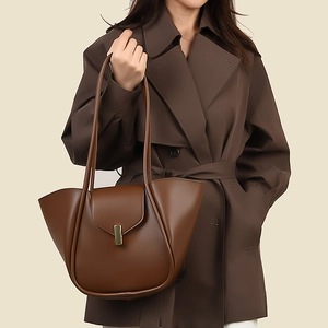 Détail de la boucle en métal verticale et du rabat sur le sac à main en cuir marron foncé