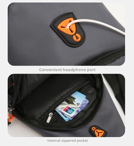 Detail of dark grey chest bag featuring a functional headphone port and inner zipper pocket