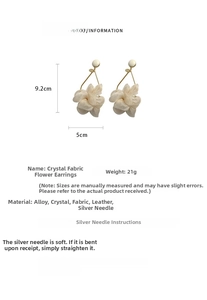 Detail view of large cream fabric flower earrings with crystal accents and measurements