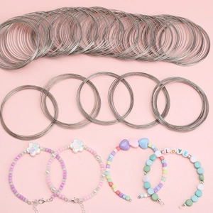 Silver memory wire coils for DIY beaded bracelets with pink and purple heart charms