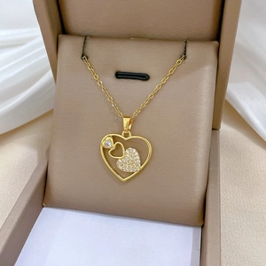 Close-up of heart pendant necklace with white zircons and a central diamond in a gift box