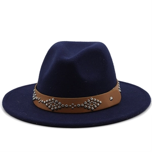 Close-up of deep blue wool fedora with brown leather rivet band and flat brim