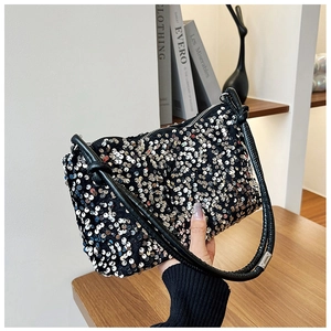 Close-up of sparkling silver sequins and black tubular knotted handle on the chic handbag