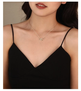 Close-up of gold 925 silver heart infinity necklace with stones on female neck