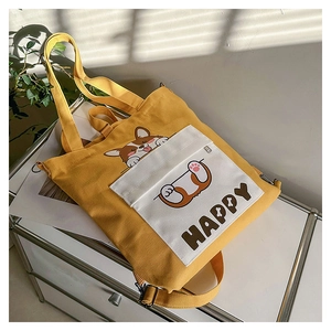 Detail of yellow canvas tote with Corgi illustration and adjustable shoulder straps