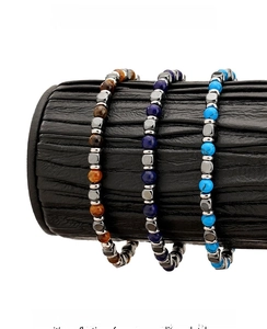Close-up of tiger eye and lapis lazuli beaded bracelets on a black display stand