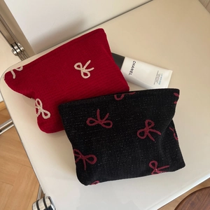 Detail of red and black corduroy cosmetic bags with elegant bow embroidery and zipper
