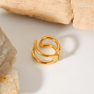 Macro view of gold-plated double-layer wave knot ring on white natural stone